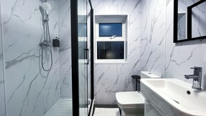 A bathroom with a glass-enclosed shower, a toilet, and a sink. - Park Inn Palace (Dover)