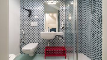 Une salle de bain avec des toilettes, un lavabo et une douche.