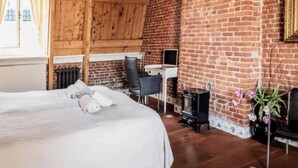 Una habitación acogedora con una cama grande, un escritorio y una chimenea.