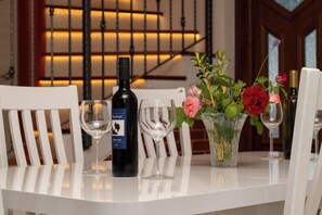 Enjoy a romantic dinner for two at this elegant dining table, complete with a bottle of wine and fresh flowers.