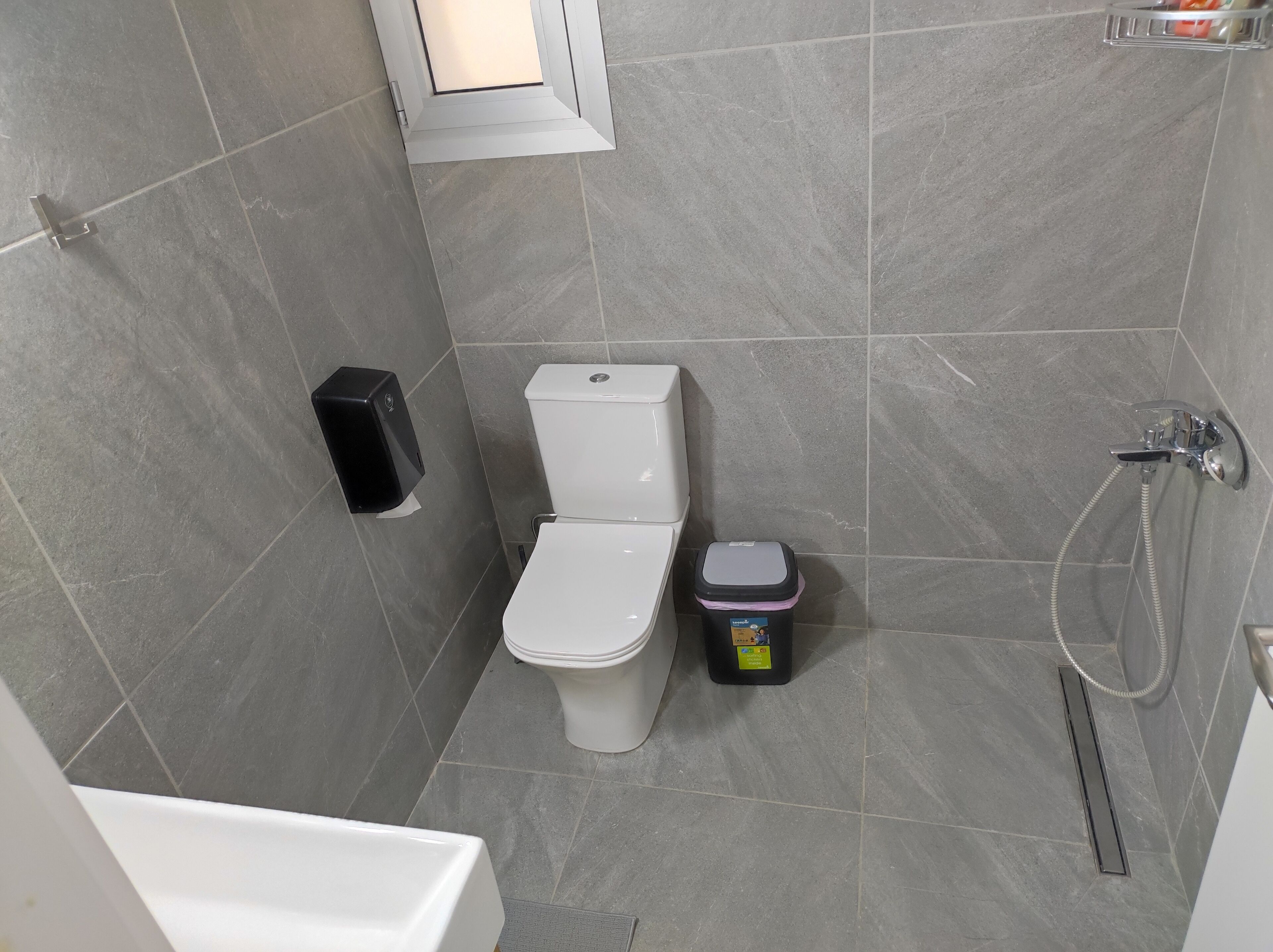 Une salle de bain moderne équipée de toilettes, d’un bidet et d’une douche.