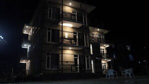 A multi-story building with balconies and a well-lit entrance. - Hotel Mountain Blue Manali (Manali)