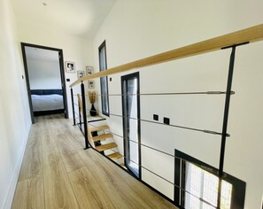 Stylish hallway leads to a cozy bedroom with a comfortable bed.