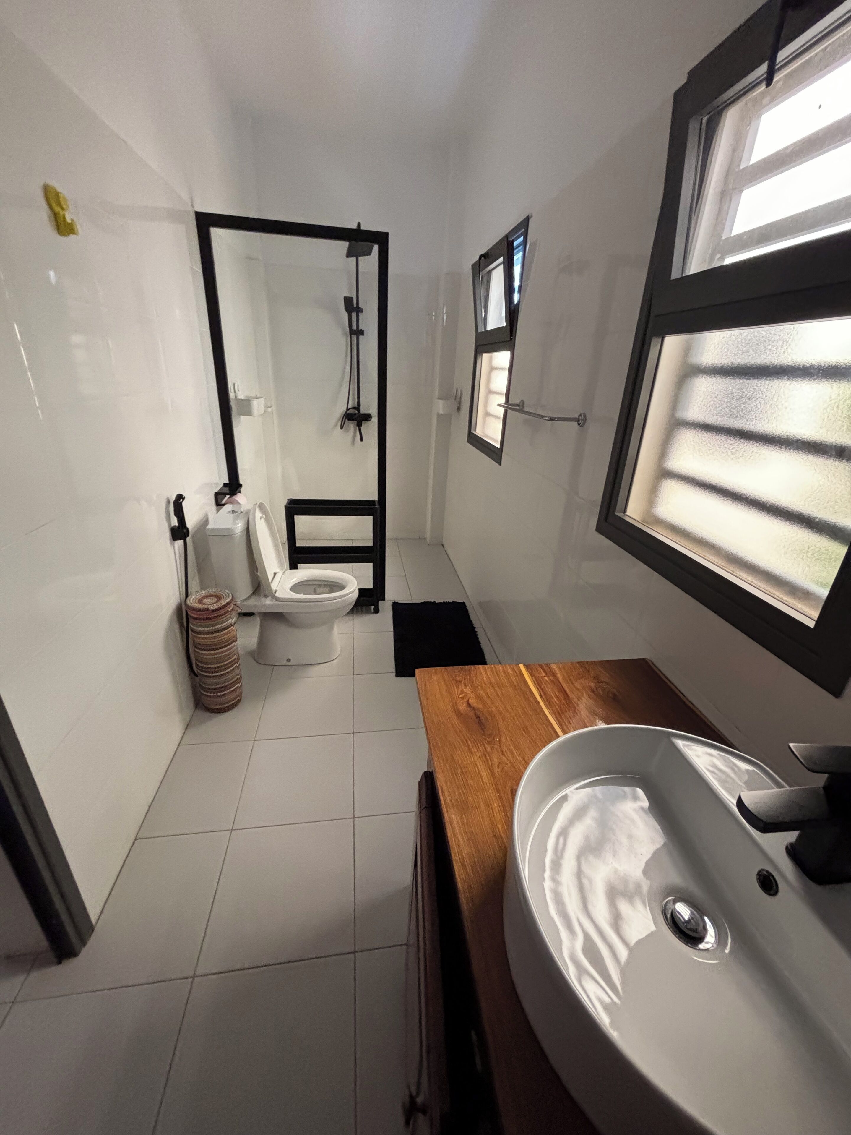 Un bagno compatto con lavandino bianco, un WC e zona doccia.