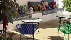 A cozy outdoor seating area with a sofa, patterned cushions, and a table. - Villa Kalélou (Nianing)