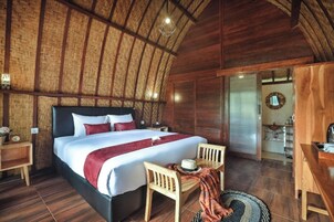 A cozy bedroom with a large bed, wooden furniture, and a rustic ceiling.