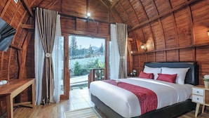 A wooden room with a bed, a desk, and a view of the outdoors. - Navalia Villa Bedugul (Baturiti)