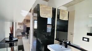 A modern bathroom with a black and white sink, a large mirror, and a glass partition. - The Flexrent Port - Abyssinia (Riccione)