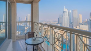 Ein Balkon mit Tisch und Stühlen, der einen Blick auf eine Skyline mit hohen Gebäuden bietet.