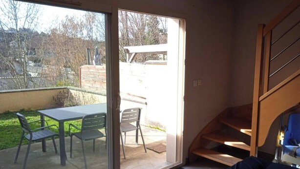 A room with a sliding glass door leading to an outdoor patio with a table and chairs. - Chez Malya, quiet house near the lake (Charavines)