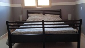 A bedroom with a bed, two bedside tables, a window, and a wall-mounted artwork. - Chez Malya, quiet house near the lake (Charavines)
