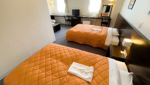 Ein Hotelzimmer mit zwei Betten, einem Schreibtisch, einem Stuhl und einem Fernseher.