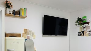 A compact, modern room with a kitchenette, a flat-screen TV, a small desk, and a round table. - moneystay deagu (Daegu)
