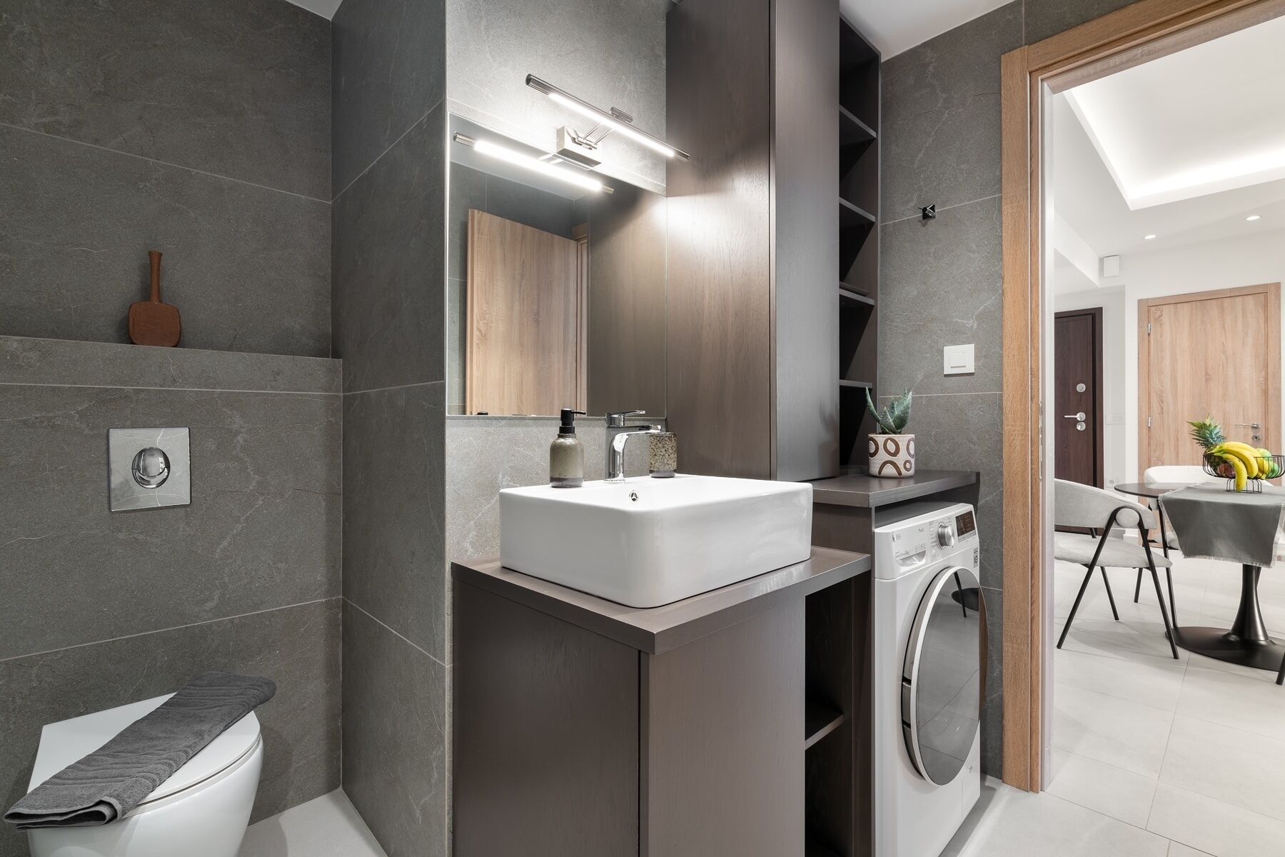Une salle de bain moderne avec un lavabo intégré, un miroir et un lave-linge.