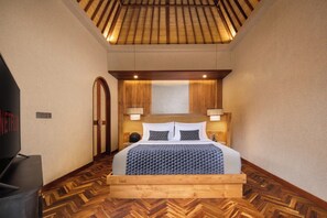 Une chambre à coucher avec une tête de lit en bois, une couvre-lit à motifs et deux lampes de chevet.