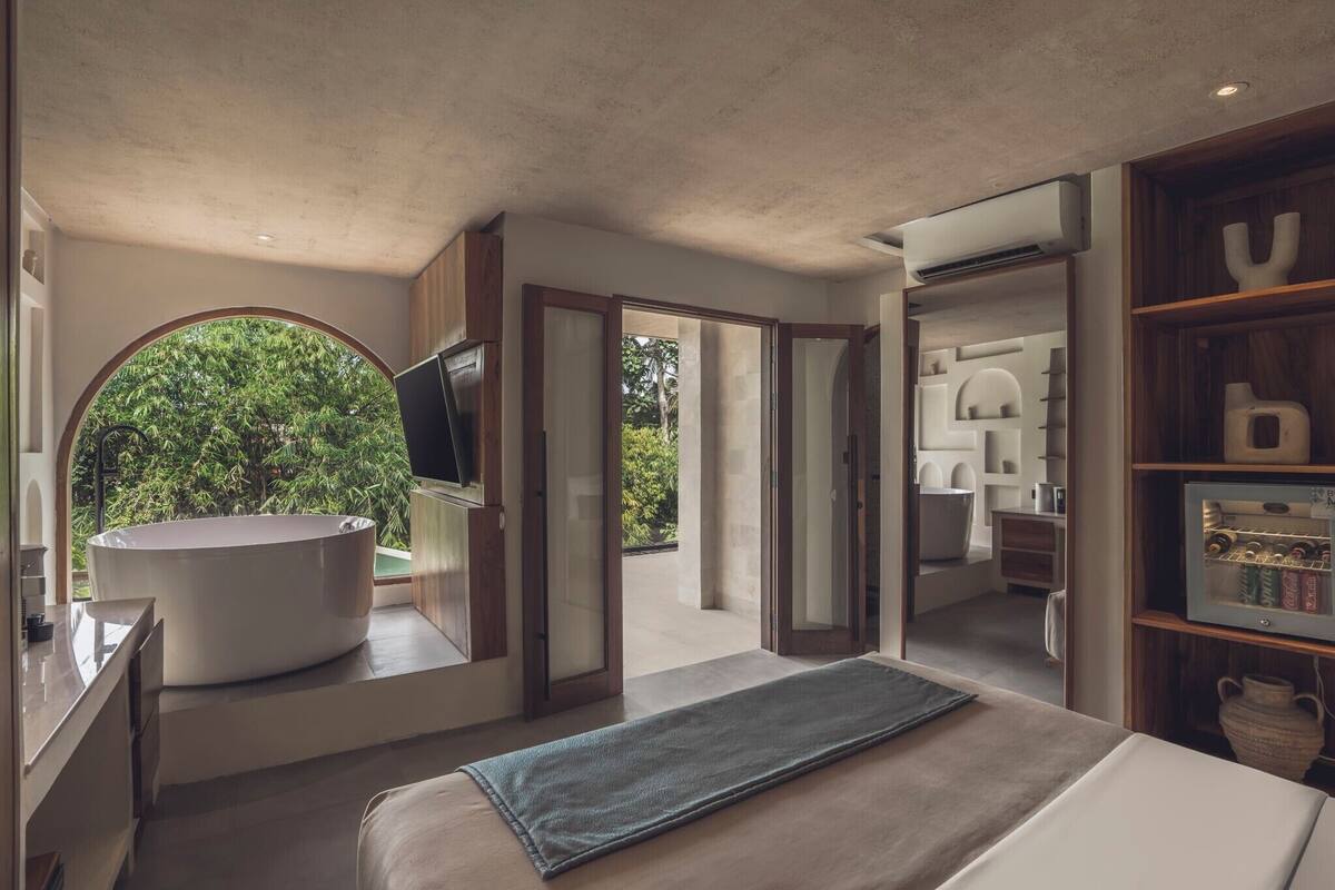 Un baño moderno con una bañera grande, un espejo y una zona de ducha.