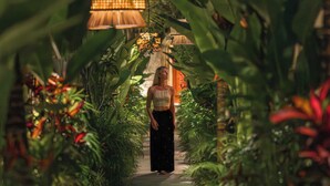 A pathway flanked by lush greenery and hanging lamps, leading to a person standing in the distance. - Asvara Resort & Spa Ubud by Ini Vie Hospitality (Ubud)