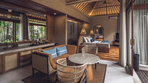 A modern hotel room with a large window, a sofa, a dining table, and a separate bedroom area. - Asvara Resort & Spa Ubud by Ini Vie Hospitality (Ubud)