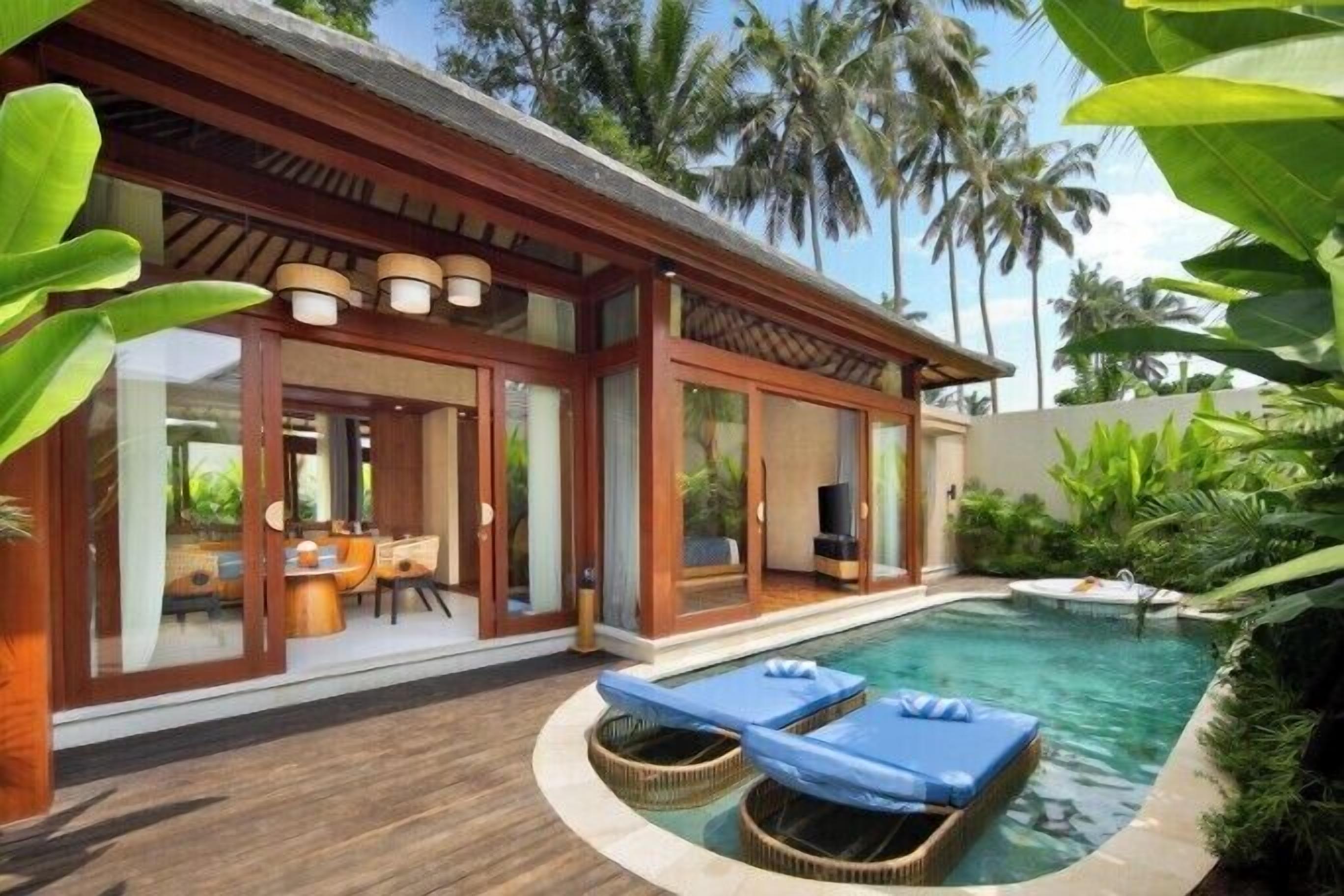 A modern house with a pool, a dining area, and a covered outdoor space.