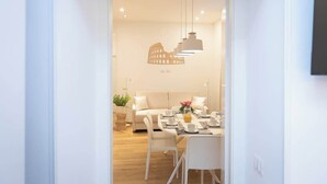 Un comedor moderno con una mesa para dos personas, un sofá y una lámpara colgante original.