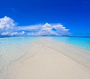 Nära stranden, vit sandstrand, parasoller och strandhanddukar