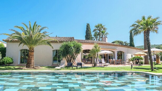 A poolside area with a tiled pool, palm trees, and outdoor seating. - Villa Alizée in St Tropez, Private swimming pool, Near town center (Gassin)