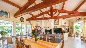 A spacious dining area with a long table, wooden chairs, and a fireplace. - Villa Alizée in St Tropez, Private swimming pool, Near town center (Gassin)