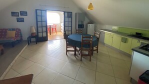 A compact living space with a dining area, kitchenette, and a sofa. - 15 minutes from the beaches of St Leu or Étang Salé. Sea view apartment with swimming pool. (Saint-Leu)