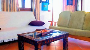 Uma sala de estar com sofá, mesa de centro e uma poltrona.