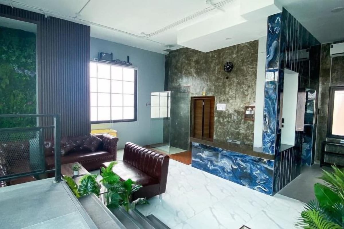 A lobby with a brown leather sofa, a reception desk, and a large window.