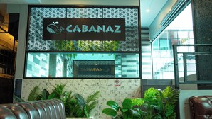 A modern interior with a 'CABANAZ' sign, seating area, and indoor plants. - Cabanaz Pool Villa (Bangkok)
