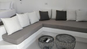 A modern living room with a sectional sofa, two wireframe coffee tables, and a remote control on one table. - Psathaki  (Kimolos)