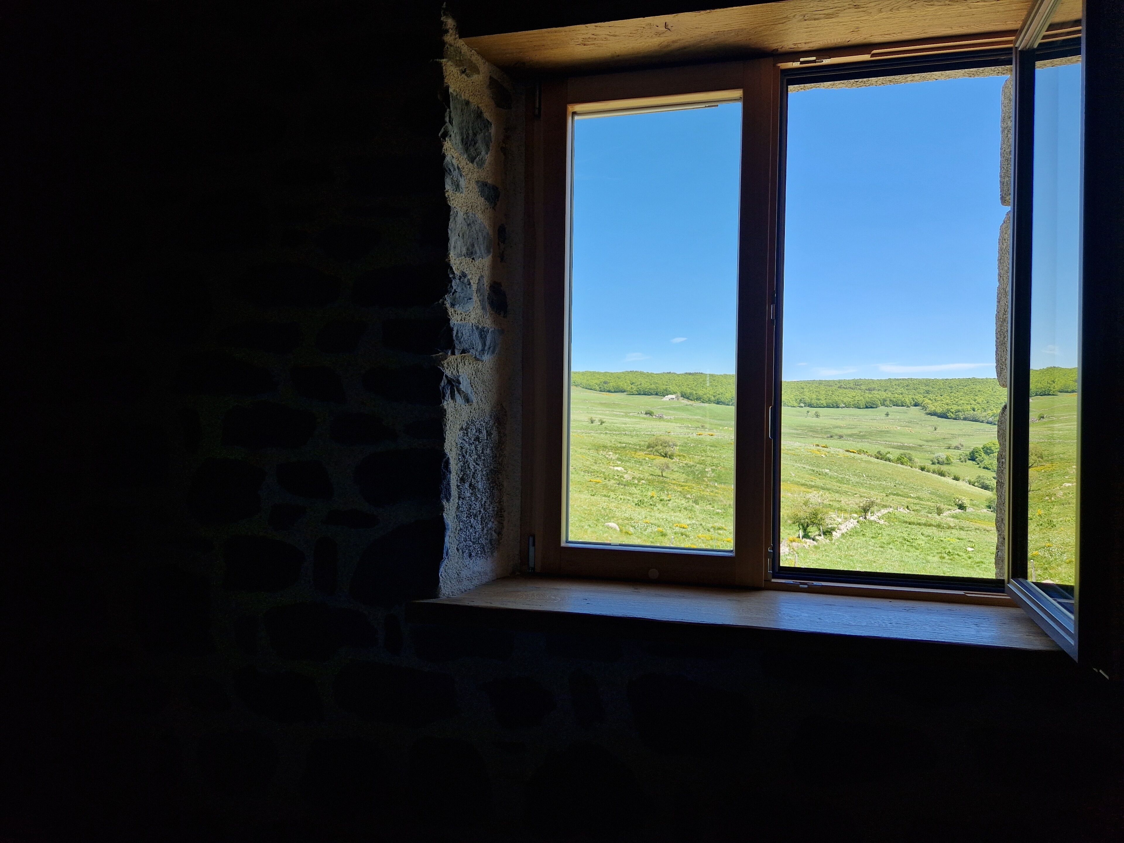 Une fenêtre donnant sur un paysage verdoyant.