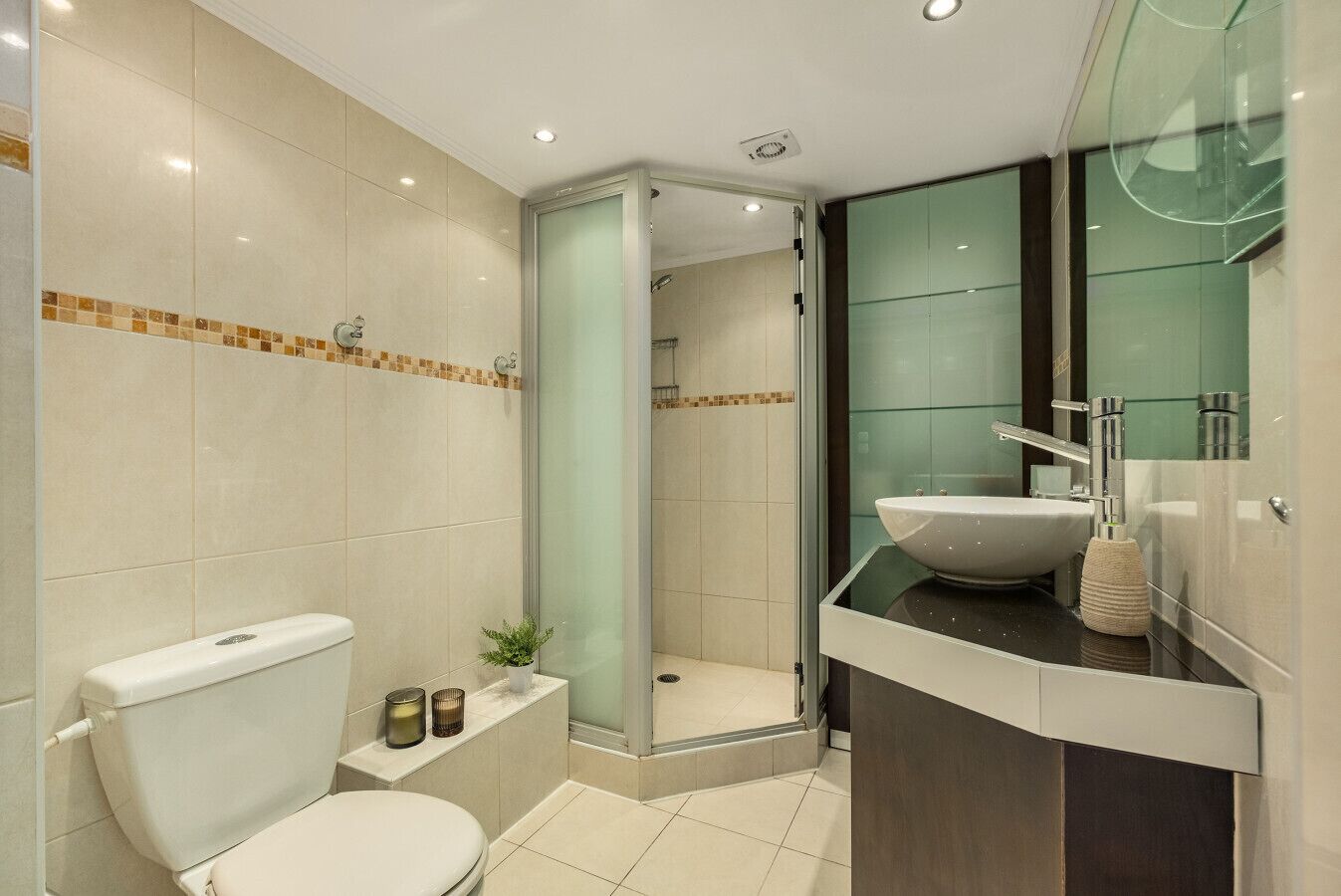 Une salle de bain moderne équipée de toilettes, d’un lavabo et d’un espace douche.