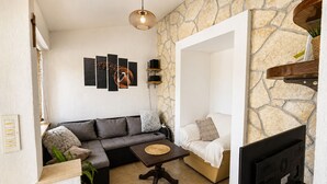 A cozy living room with a sofa, a coffee table, and a TV. - Family Home Iskra (Bulic)