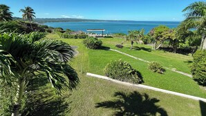 Un paisaje verde exuberante con vista despejada al océano y un pabellón.