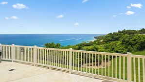 A balcony with a view of the ocean and a sign indicating a parking area.