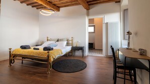 A bedroom with a bed, bedside table, and a desk with a chair.