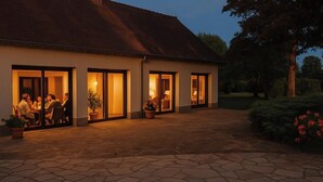 Un bâtiment à deux étages, doté d’une façade en pierre et d’un patio couvert.