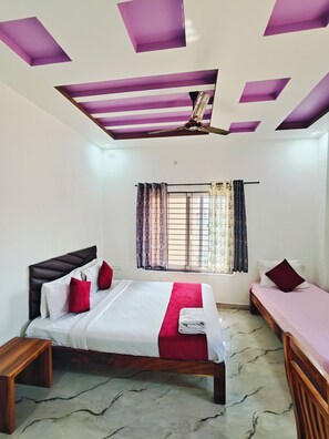 A bedroom with a bed, bedside tables, a ceiling fan, and a window with curtains. - PPH Living Jai Maruthi Boarding&Lodging (Ramanagara)