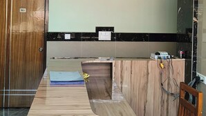 Une cuisine moderne dotée d’un plan de travail en marbre, d’une porte en bois et d’un ventilateur de plafond au design original.