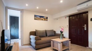 A modern living room with a sofa, a coffee table, and a painting on the wall. - Apartman Mrkonjic-Pula (Pula)