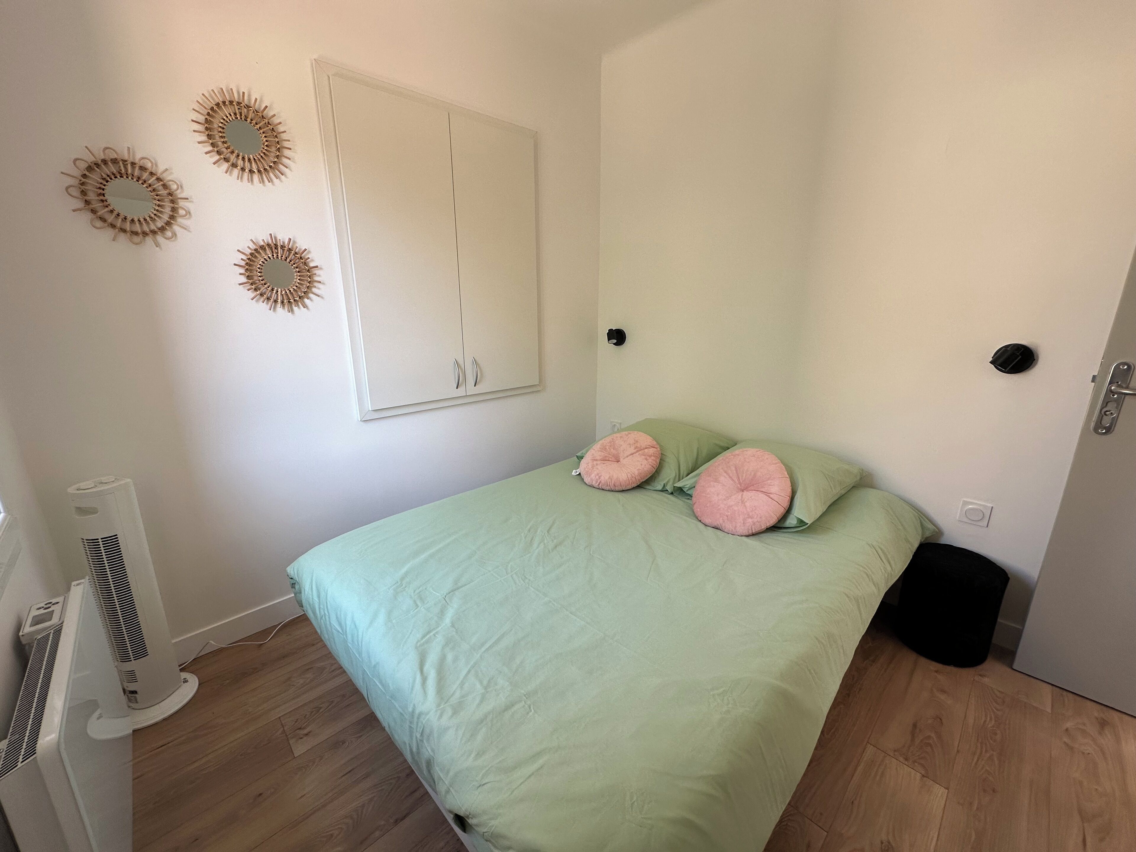 A bedroom with a bed, a wardrobe, and wall decorations.