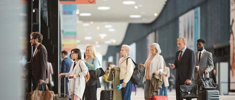 Un grupo de personas en una terminal, con equipaje, esperando su partida.
