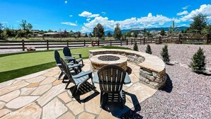 A patio with stone flooring, outdoor seating, and a fire pit.