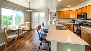 Une cuisine moderne avec des meubles en bois, un grand îlot central et un coin repas avec des chaises.