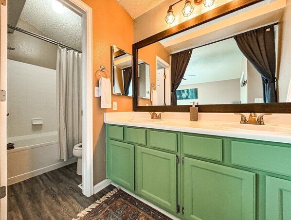 A bathroom with a shower, a sink, and a mirror.