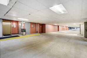 A clean, empty hallway with a yellow doormat, a vending machine, and a door with a security camera. - Gateway Lodge Pool & Spa Studio | Walk to Lifts! (Keystone)