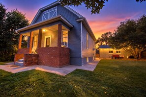 A two-story house with a covered porch and a small attached garage.