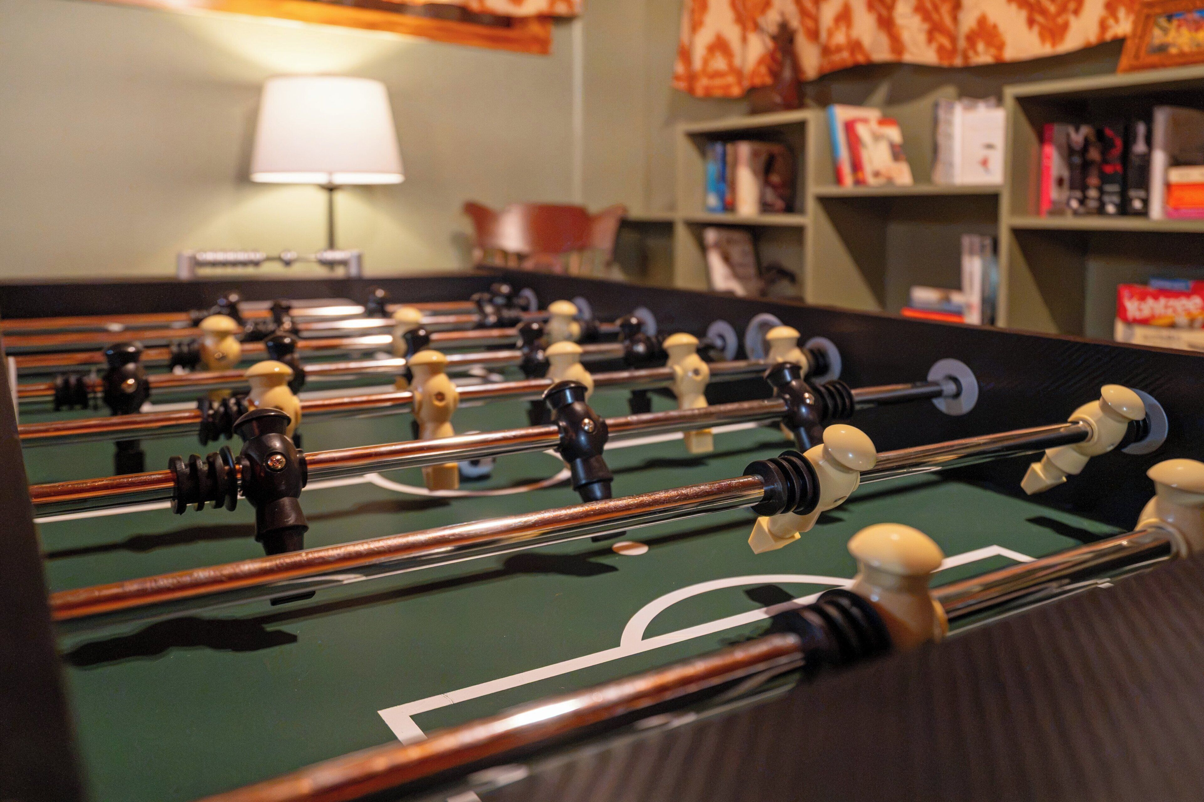 A foosball table with a green playing surface and multiple foosball figures.